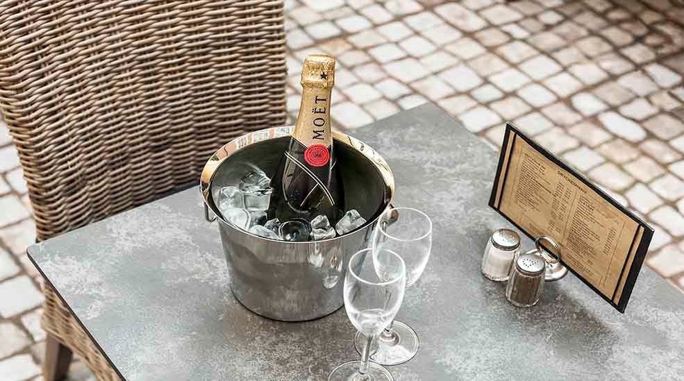 Restaurant med bord og stole med champagne og menu hos Clarion Collection Hotel Victoria Jönköping 