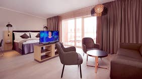 Deluxe dobbeltværelse med seng, tv, siddegruppe og vinduer hos Clarion Collection Hotel Hammer