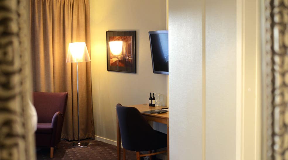 Skrivebord med siddegruppe og tv i superior værelse hos Clarion Collection Hotel Kompaniet Nyköping