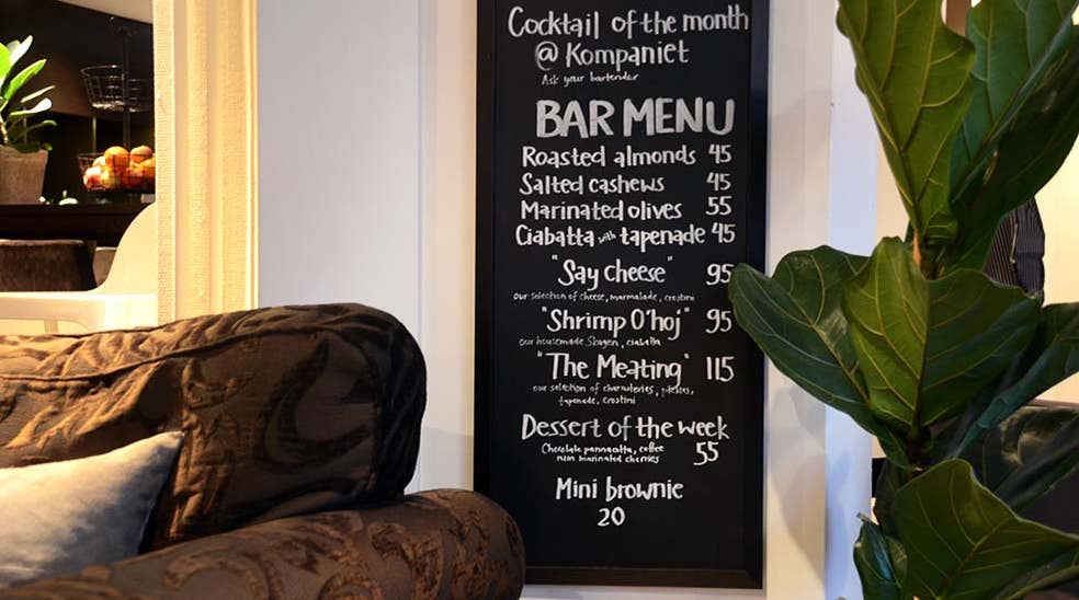 Bar menu i restaurant med stol og plante hos Clarion Collection Hotel Kompaniet Nyköping
