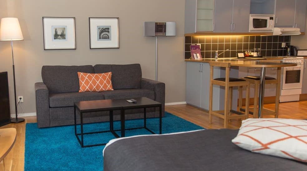 Stue med sofa og køkken i superior dobbeltrum på Clarion Collection Hotel Odin Göteborg 
