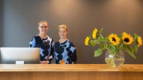 To glade receptionister i lobbyen på Hotel F6 i Helsinki, Finland