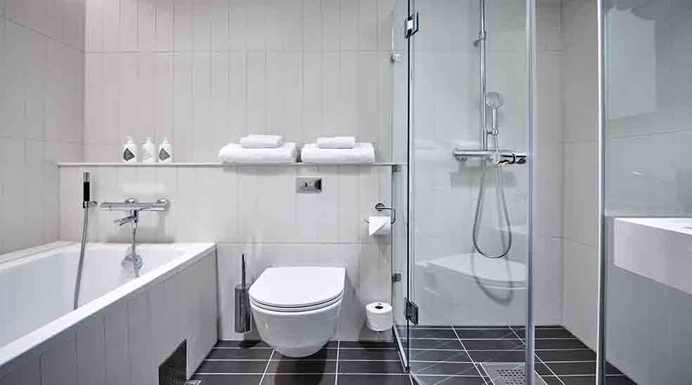 Stilrent badeværelse med toilet, bruser og badekar på Nordic Light Hotel i Stockholm