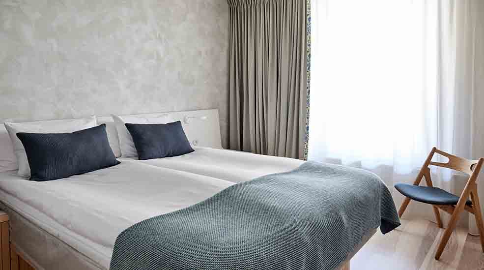 Dobbeltseng og stol i Standard Single hotelværelse med vindue på Nordic Light Hotel i Stockholm