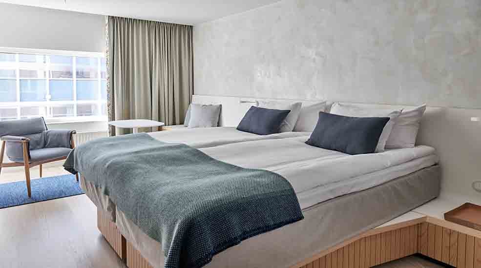 Dobbeltseng og stol i skandinavisk design i Superior Double hotelværelse med vindue på Nordic Light Hotel i Stockholm