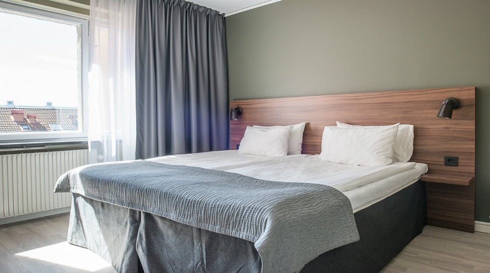 Sengeområde i Standard dobbeltværelse med dobbeltseng, vindue og natlamper hos Quality Hotel Grand Kristianstad